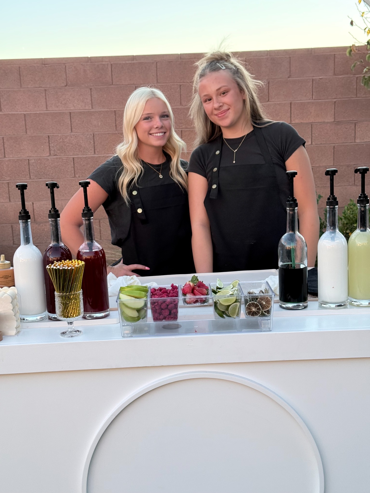 Golden Hour Events team behind a white drink cart with syrups and fresh fruit garnishes at the Utah Tech Kickball Draft Party